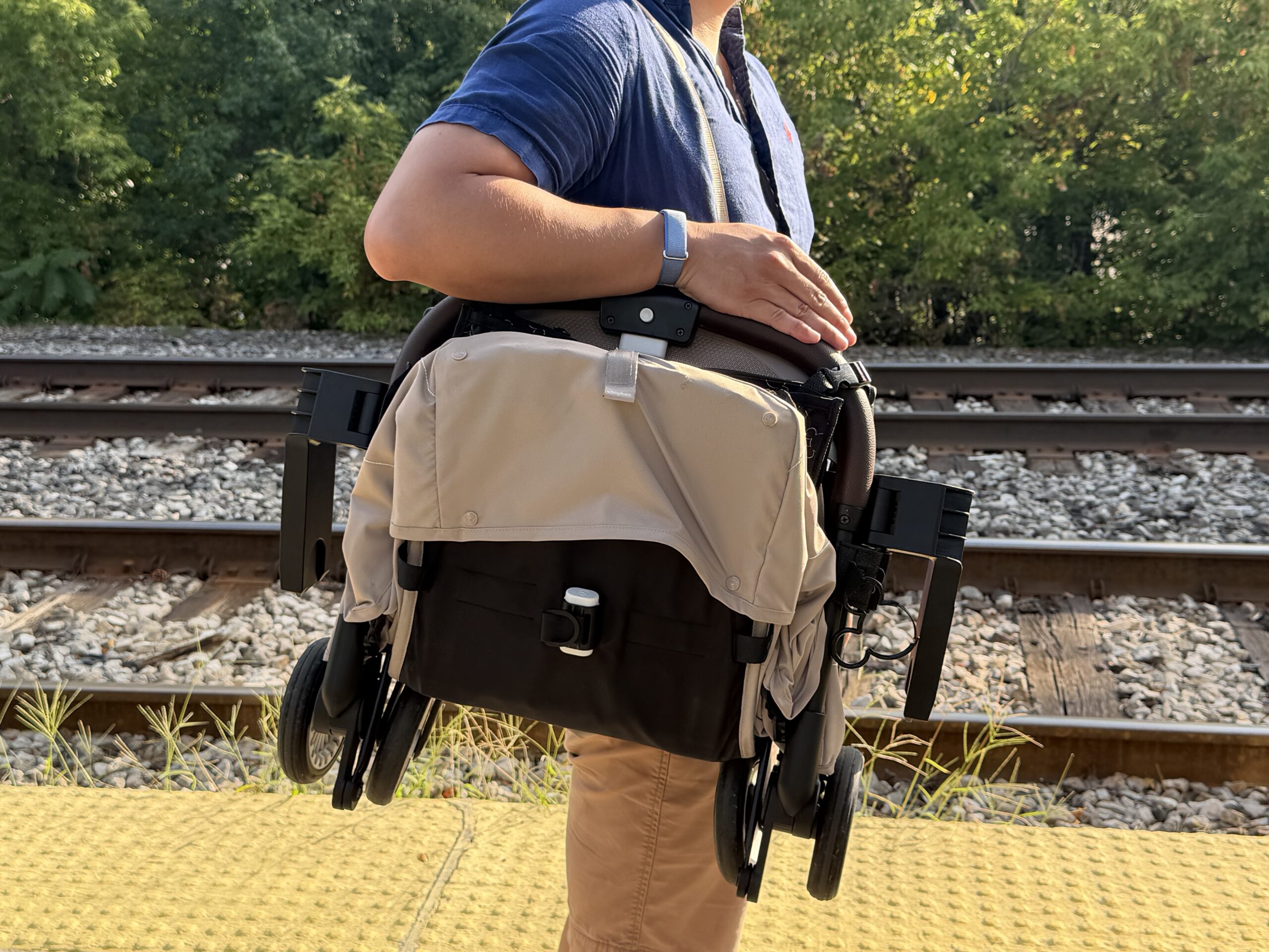 Cybex Orfeo 4 pliée et portée en bandoulière à l’épaule