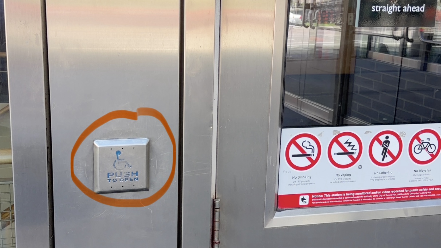 Bouton d’ouverture accessible identifié par un pictogramme fauteuil roulant dans une station de Toronto