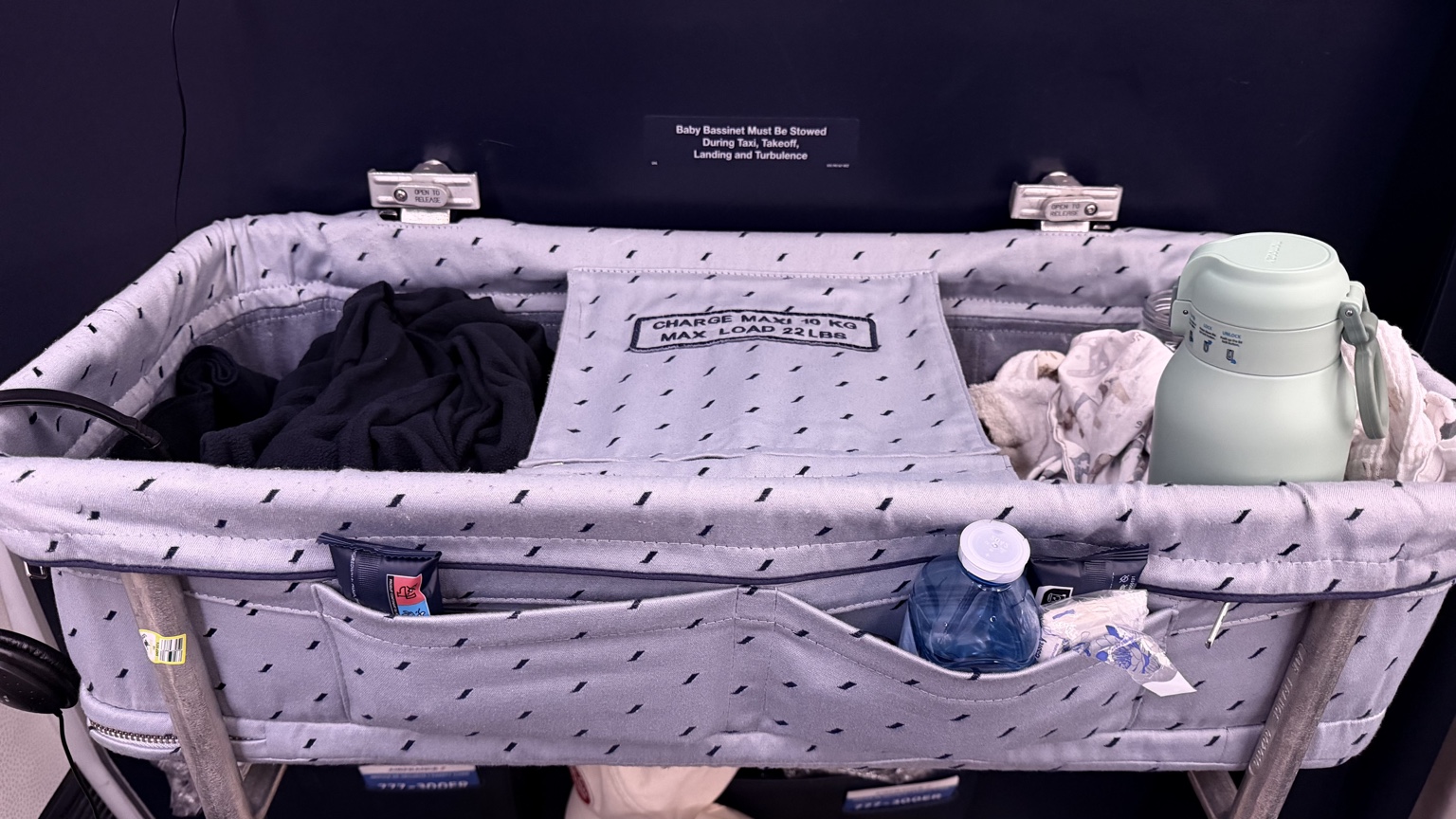 Berceau Air France installé sur la cloison devant les sièges, avec ses poches de rangement