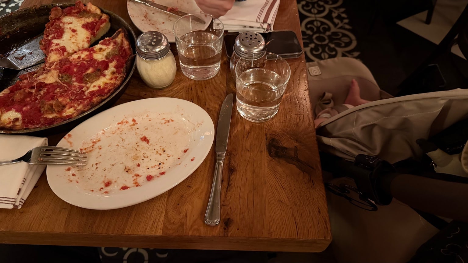 Table avec une pizza chez Labriola et poussette placée juste à côté.